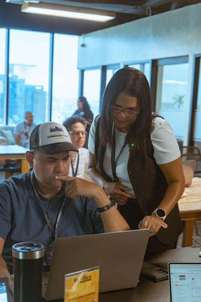 Keisa Ávila sonriendo mientras acompaña a un asistente en AWS Community Day Panamá