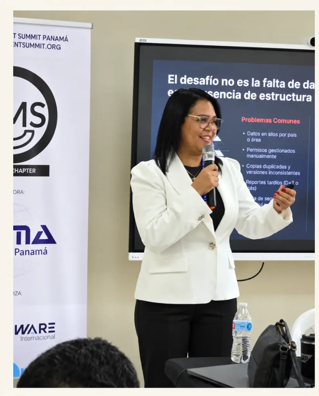 Keisa Ávila en su charla en DAMA Panamá, frente a una lámina sobre la falta de estructura en los datos
