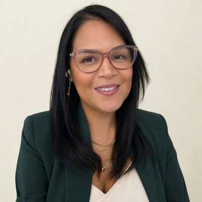 Keisa Ávila, especialista en IA aplicada a negocio, con lentes y blazer verde